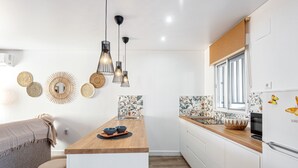 Une cuisine moderne avec un îlot central en bois, des armoires blanches et une fenêtre offrant une belle vue.