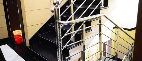 A staircase with metal railings and black steps.