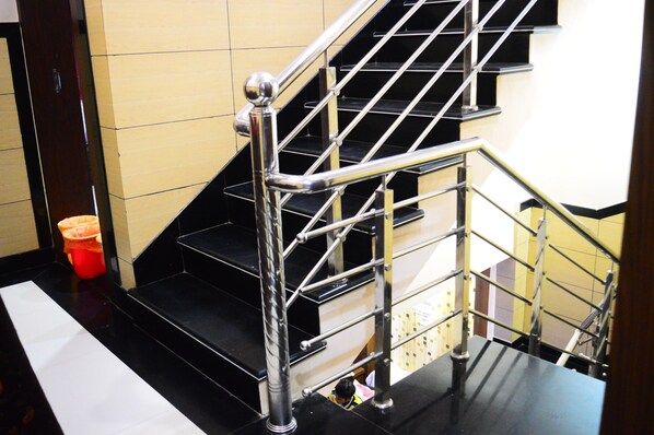A staircase with metal railings and black steps.