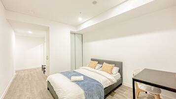 Ein modernes Schlafzimmer mit Bett, Schreibtisch und Stuhl.
