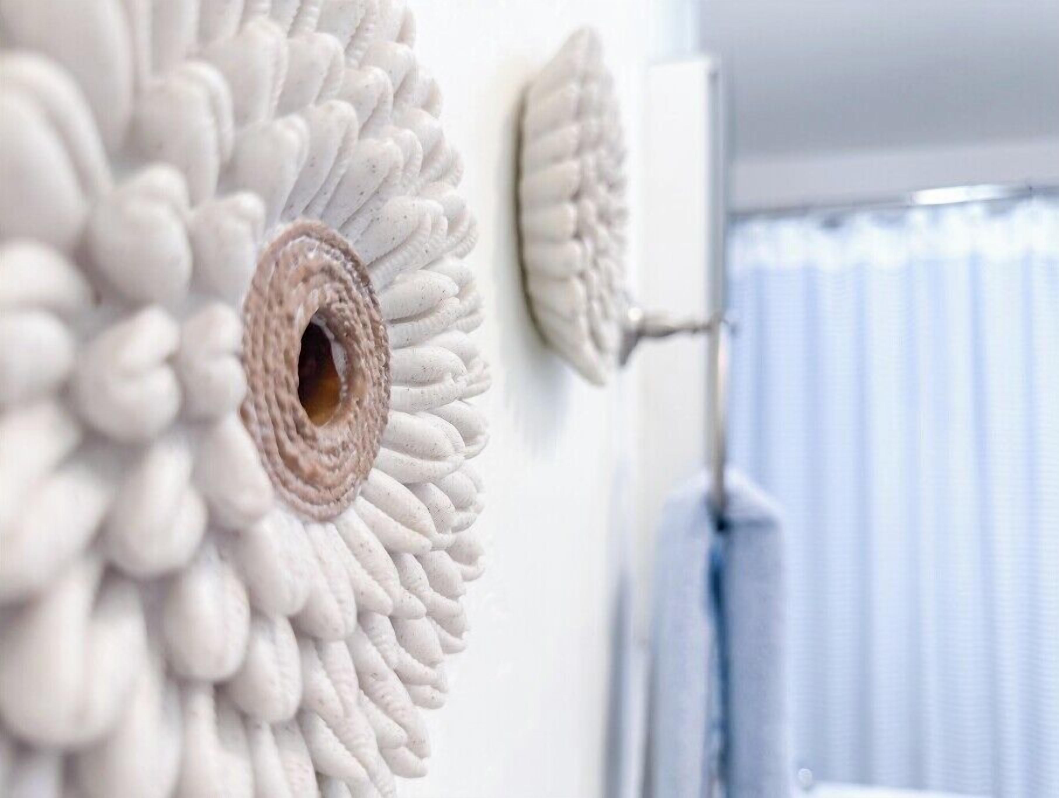 A wall with a textured, circular pattern, possibly a decorative element or a wall-mounted device.