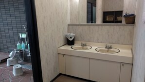 Een badkamer met twee wasbakken, een spiegel en een douche.