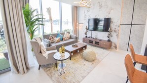 Leilighet – deluxe | Oppholdsområde | En 65-tommers smart-TV med digitale kanaler