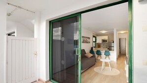 A modern apartment with a sliding glass door leading to a living area, a kitchen, and a dining space. - Vacation Apartment 'Dreams' with Sea View, Shared Pool and Wi-Fi (Puerto Rico)