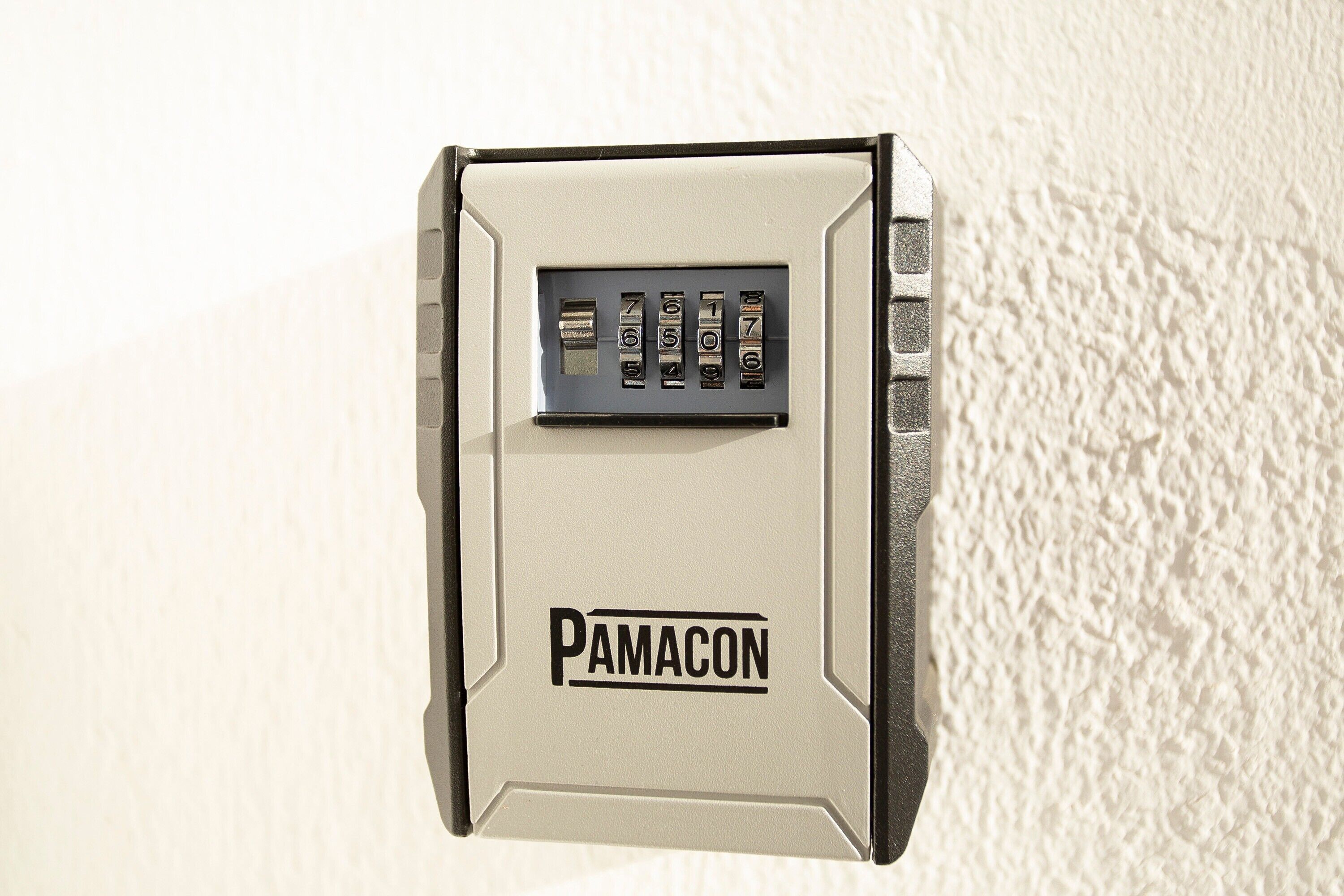 A wall-mounted security device with a keypad and the brand name 'PAMACON' visible.