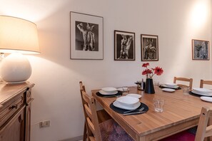 A dining table set with plates, glasses, and a vase with flowers.