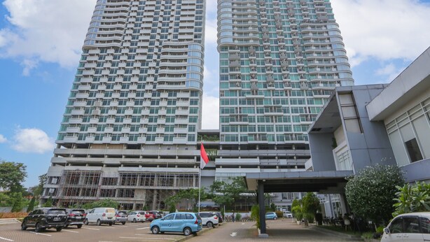 Two high-rise buildings with a modern architectural design, featuring multiple balconies and large windows. - OYO 93432 Tree Room Hotel (Tangerang)