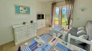 Un espacio habitable compacto con kitchenette, comedor y sofá.