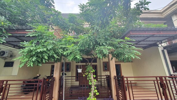 A building with a covered entrance, a staircase, and a metal gate. - Hotel O Damia Homestay Syariah (Surabaya)