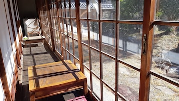 Una habitación con piso de madera, un banco y vistas amplias a través de grandes ventanales.