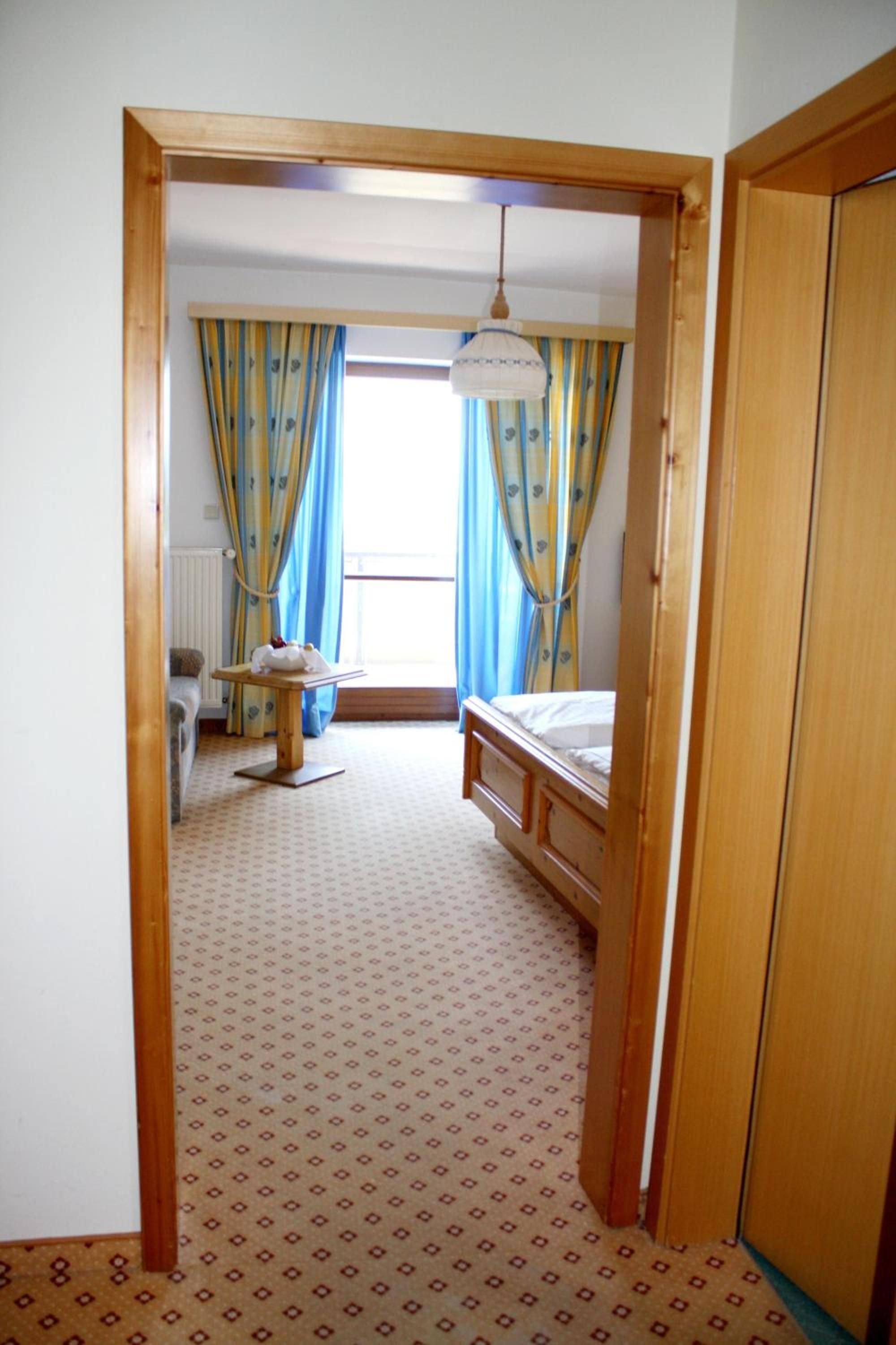 Ein Zimmer mit einem Bett, einem kleinen Tisch und einer Heizung.