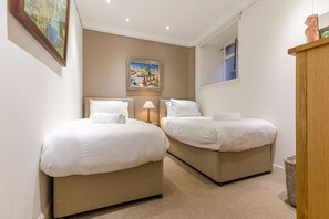 A hotel room with two beds, a painting on the wall, and a window with a view. - House On The Harbour | Pittenweem (Pittenweem)