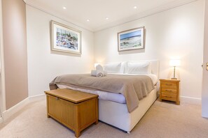 A bedroom with a bed, bedside tables, a nightstand, and two framed pictures on the wall. - House On The Harbour | Pittenweem (Pittenweem)