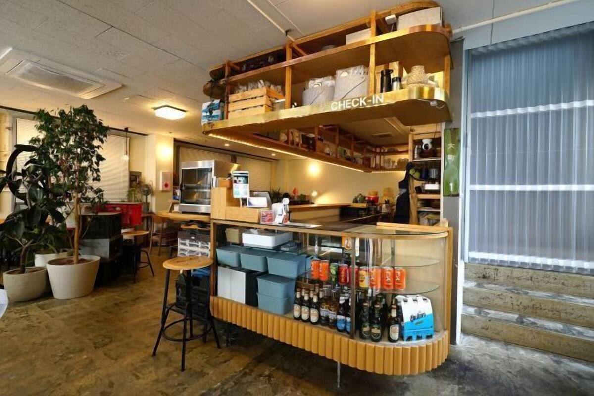 Un mostrador de recepción con estanterías de madera, una vitrina de cristal y plantas en macetas.