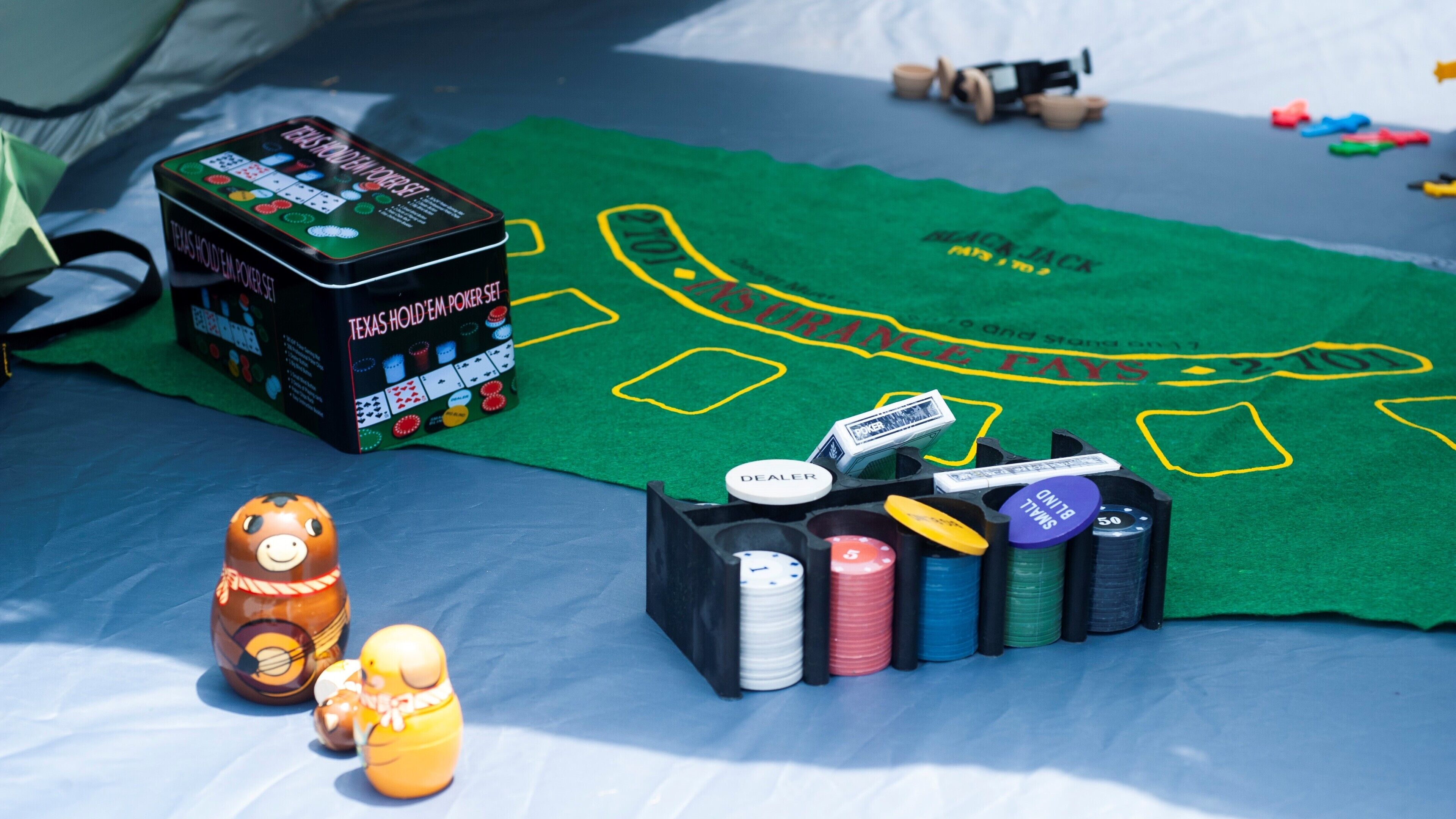 A poker set, dice, and toy figures on a green felt surface with a board game layout.
