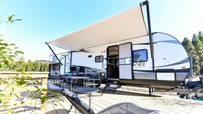 A recreational vehicle with a covered deck area, a table, and chairs. - Franping Village Aso (Aso)
