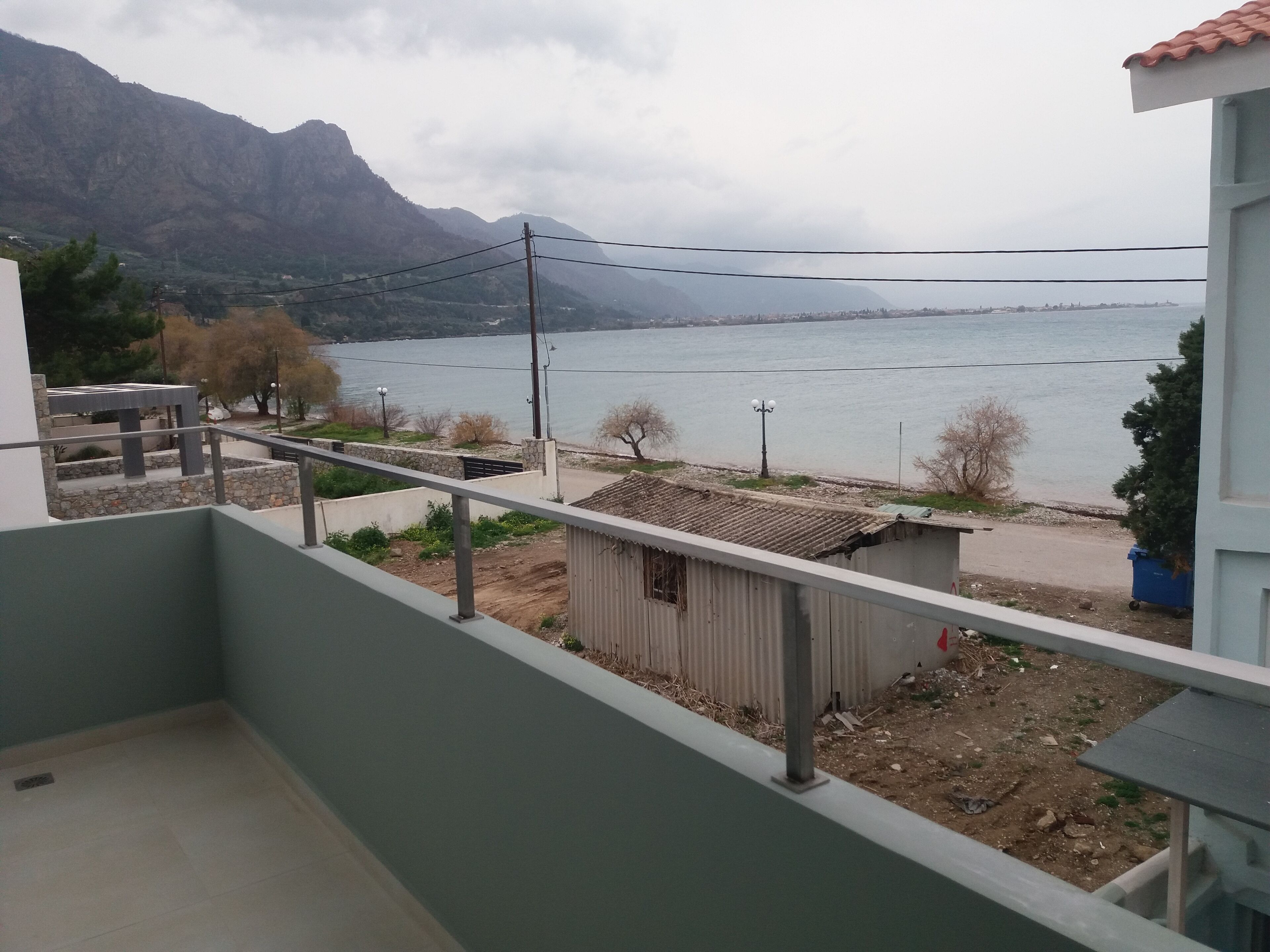 A balcony with a view of a lake and mountains.