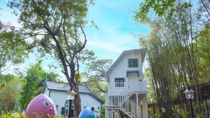 A building with a staircase and a garden with large sculptures. - Dara Express by Angkor Green Gardens (Siem Reap)