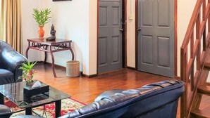 A spacious living area with a high ceiling, a ceiling fan, a staircase, and a view of the outside. - Dara Express by Angkor Green Gardens (Siem Reap)
