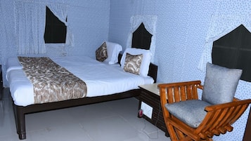 Un dormitorio con una cama, una silla de madera y una mesita de noche.