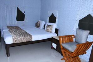 Ein Schlafzimmer mit einem Bett, einem Holzstuhl und einem Nachttisch.