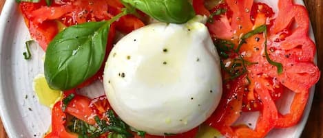 A plate of Caprese salad with tomatoes, mozzarella, and basil.