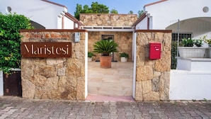 Um portão de entrada de pedra com uma placa indicando 