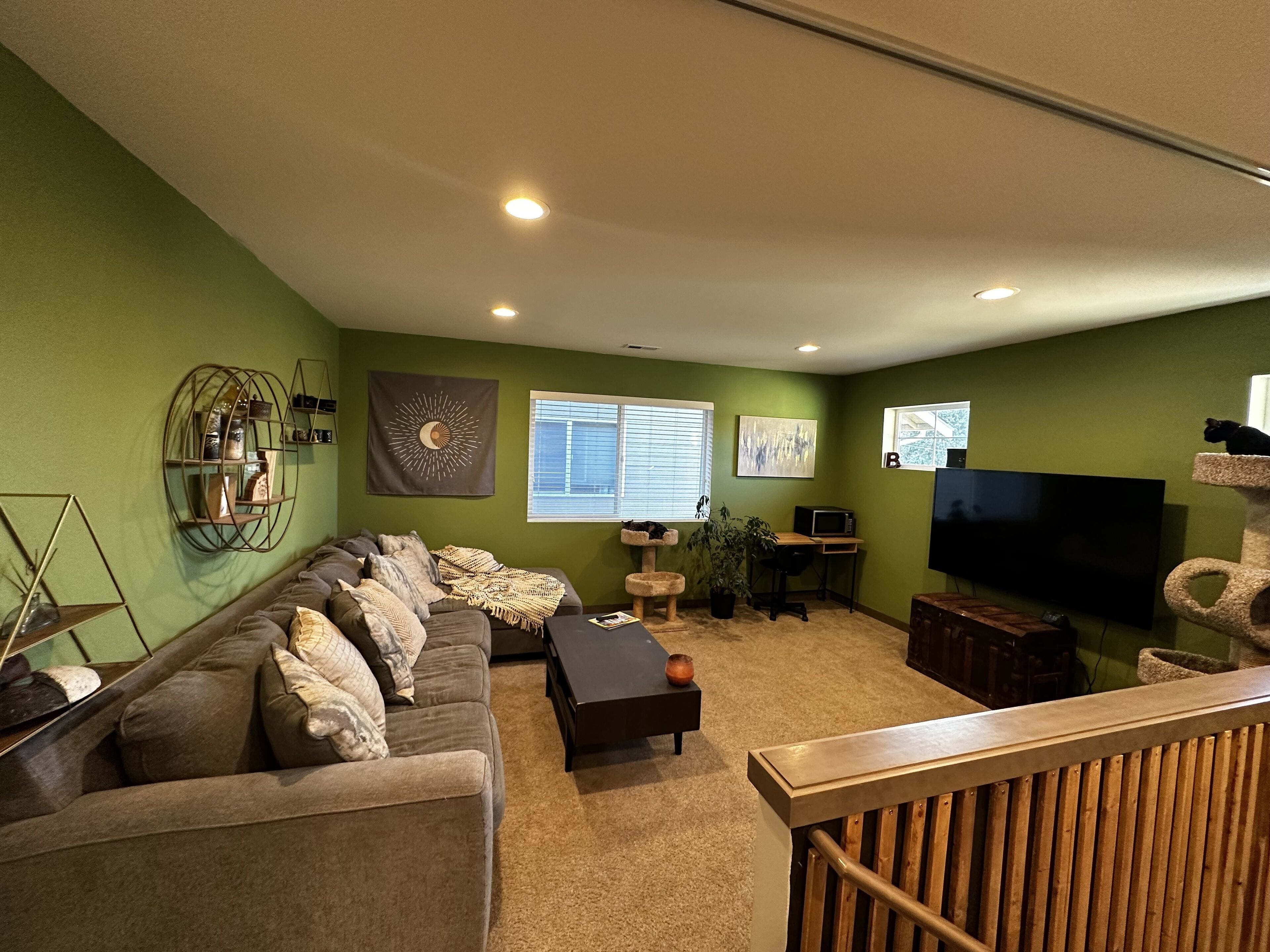 A living room with a sofa, coffee table, TV, and a cat tree.