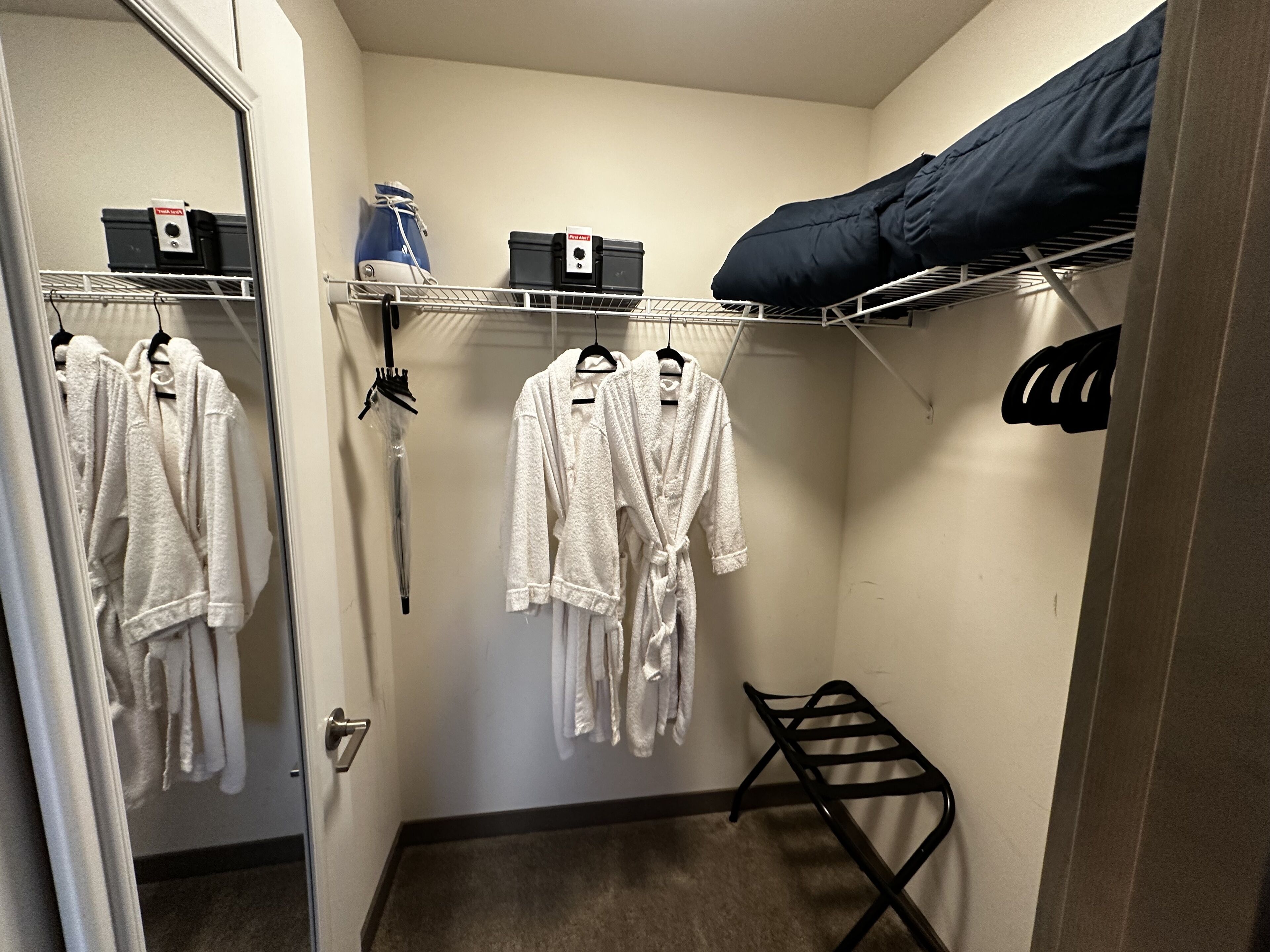 A small, compact room with a bunk bed, a drying rack, and a mirror.