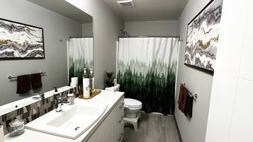 A modern bathroom with a large mirror, a white sink, a toilet, and a shower curtain with a forest design.