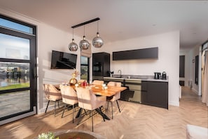 Eine moderne Küche mit Essbereich, großen Fenstern und Blick ins Freie.