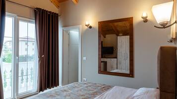 A bedroom with a wooden ceiling, a bed with a patterned bedspread, a large mirror, and a chair.