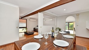 Enjoy meals with friends and family in this spacious dining area, featuring a long table and comfortable seating for six.