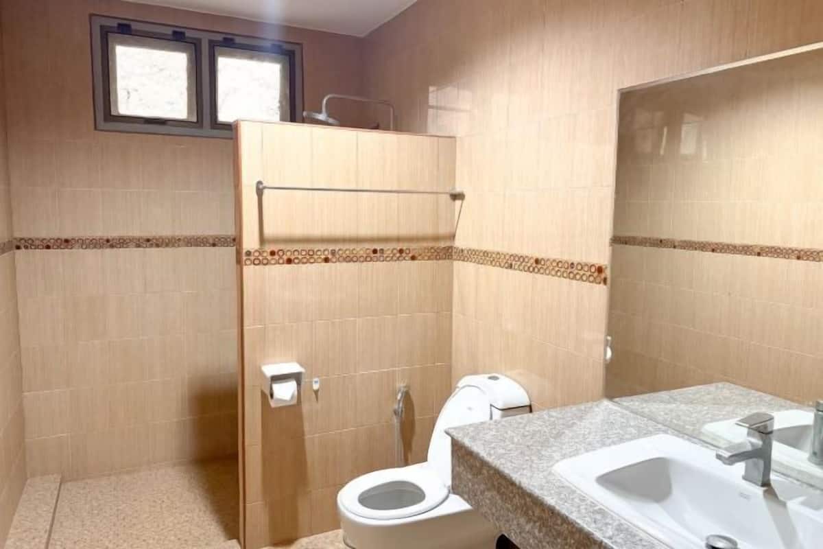 A bathroom with a toilet, shower, and sink.