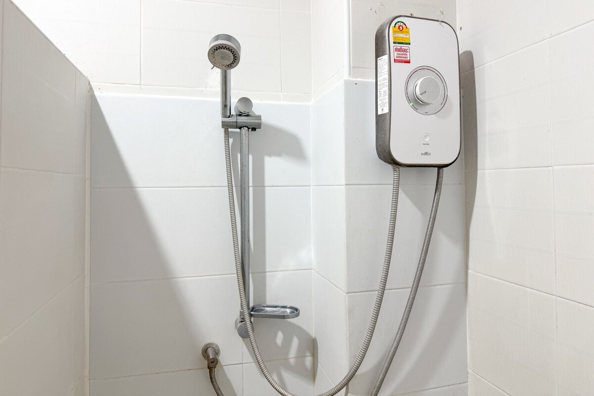 Ducha con cabezal de ducha de mano y panel de control en la pared.