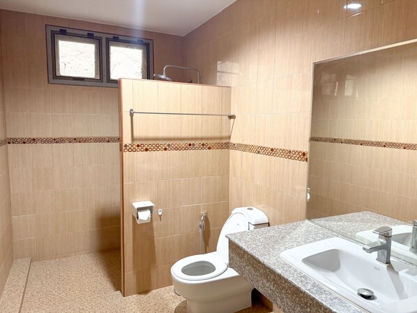 Un baño con ducha, inodoro y lavamanos.
