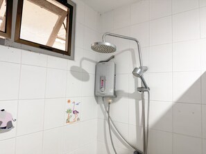 Una ducha con cabezal de ducha de mano y panel de control en la pared.