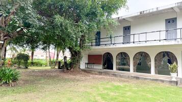 Un edificio con un espacio al aire libre techado, una escalera y un árbol.