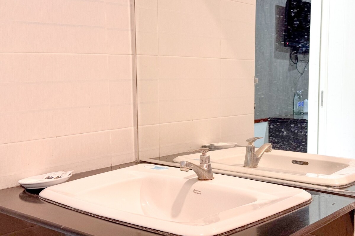 A bathroom with two sinks, a mirror, and a tiled wall.