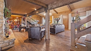 A spacious living area with a fireplace, sofas, and a staircase leading to another level. - Landing(43M0)- Sleeps 20 + Airway Strip + Hot Tub (Pleasant Hill)