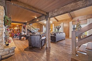 A spacious living area with a fireplace, sofas, and a staircase leading to another level. - Landing(43M0)- Sleeps 20 + Airway Strip + Hot Tub (Pleasant Hill)
