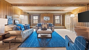 A spacious living room with a large sofa, a coffee table, and a television. - Landing(43M0)- Sleeps 20 + Airway Strip + Hot Tub (Pleasant Hill)