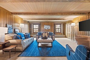 A spacious living room with a large sofa, a coffee table, and a television. - Landing(43M0)- Sleeps 20 + Airway Strip + Hot Tub (Pleasant Hill)