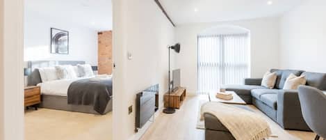 Un salón moderno con un sofá, una mesa de centro y un mueble para la televisión.