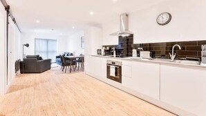 A modern kitchen with a built-in oven, a microwave, and a stainless steel range hood.