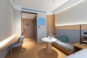 A modern hotel room with a wooden desk, a round table, a sofa, and a bed. - Ji Hotel Wuhan Hannan Xingcheng Avenue (Wuhan)