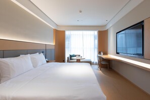 A modern hotel room with a large bed, a desk, a chair, and a television. - Ji Hotel Wuhan Hannan Xingcheng Avenue (Wuhan)