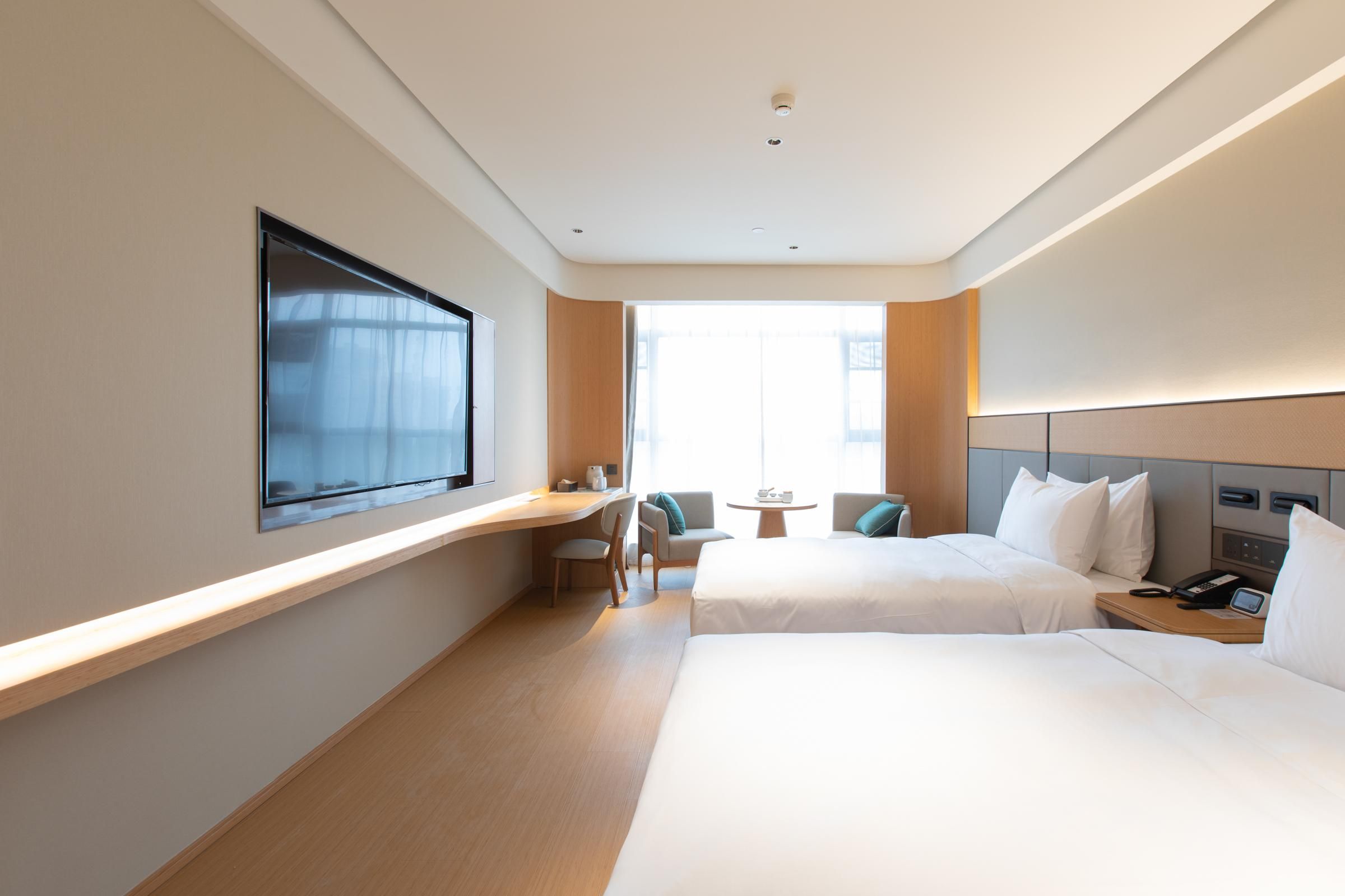 Una habitación de hotel con una cama grande, un escritorio, una silla y una mesita.
