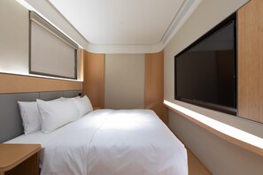 A modern hotel room with a large bed, a bedside table, a TV mounted on the wall, and a window providing natural light. - Ji Hotel Wuhan Hannan Xingcheng Avenue (Wuhan)