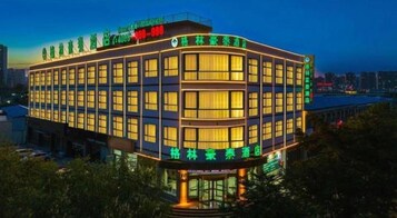 Un hotel de varios pisos con fachada curva, ventanas amplias y señalización que indica las comodidades.